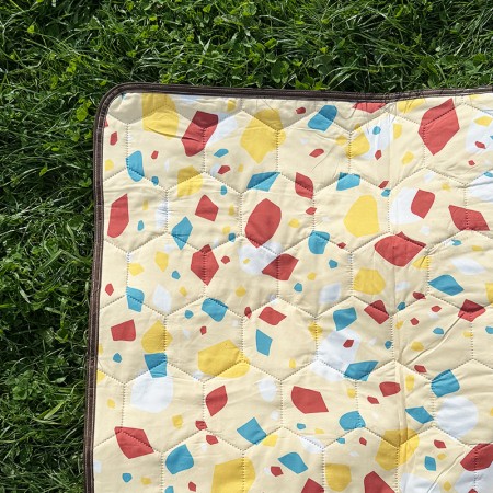 Picnic pad Wildland couverture de pique-nique isolante et imperméable jaune déroulée sur l'herbe